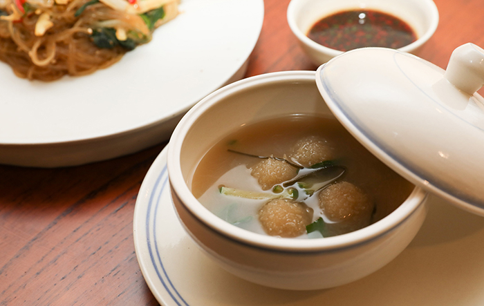 Korean japchae cellophane noodles (left) and stir-fried vegetables and gamja ongsimi (potato dough soup)