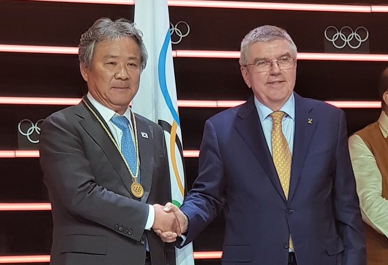 Lee Kee-heung, president of the Korean Sport & Olympic Committee, on June 26 shakes hands with Thomas Bach, president of the International Olympic Committee (IOC), after Lee’s election as an IOC member during the 134th IOC session. (Korean Sport & Olympic Committee)