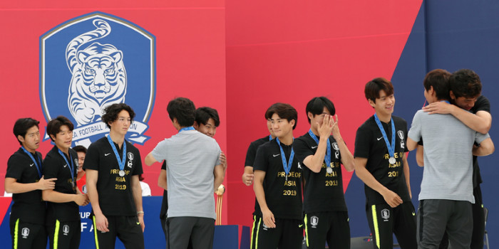 U-20 head coach Chung Jung-yong and his staff on June 17 hug their players at the end of their welcoming ceremony at Seoul Plaza.