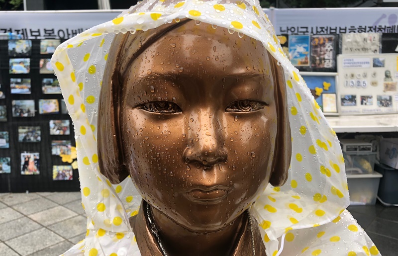 The final destination of the marchers was "The Statue of Peace," which presents the image of a Korean comfort woman. Both Korean and Japanese attendees put a raincoat on the lone statue. Amid heightened tension between Korea and Japan over historical issues, are the drops on the statue